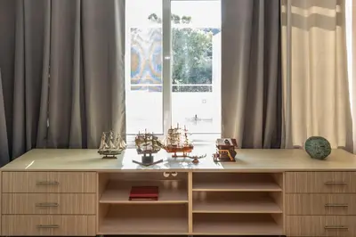 a desk with many items on it in front of a window at Michele Studio in Artemida