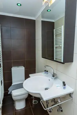 a bathroom with a white sink and a toilet at Michele Studio in Artemida