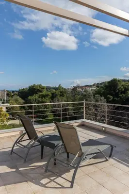 two chairs sitting on a balcony with a view at Michele Studio in Artemida