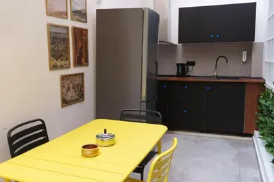 a kitchen with a yellow table with chairs and a sink at Sani Suite 7 in Athens