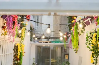 a string of lights hanging from a building with flowers at Sani Suite 7 in Athens
