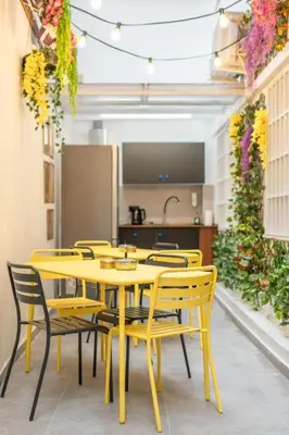 a yellow table and chairs in a room with a kitchen at Sani Suite 7 in Athens
