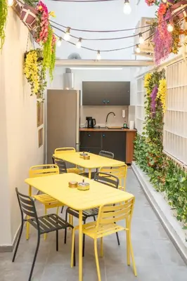 a restaurant with yellow tables and chairs and a kitchen at Sani Suite 7 in Athens
