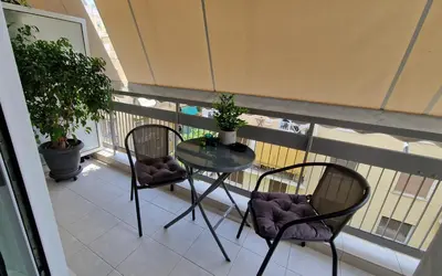 a balcony with a glass table and two chairs at Cozy apartment in Athens in Athens