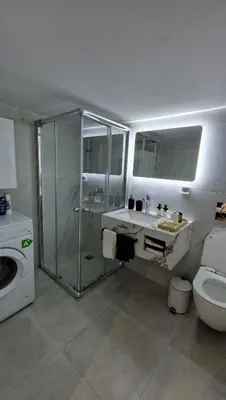a bathroom with a shower and a sink and a washing machine at Cozy apartment in Athens in Athens