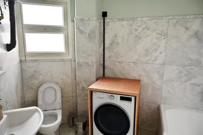 a bathroom with a washing machine and a toilet at Brand New! Vintage Charm, Modern Comfort in Athens