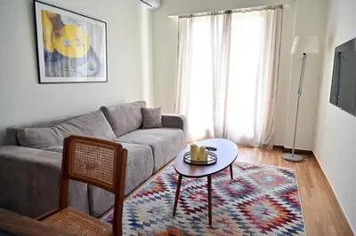a living room with a couch and a table at Brand New! Vintage Charm, Modern Comfort in Athens