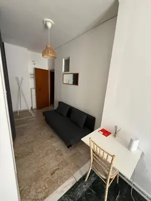 a living room with a black couch and a table at Cósy apartment in Palaiá Fókaia