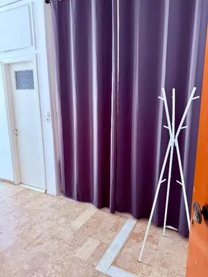 two windmills standing in a room with purple curtains at Cósy apartment in Palaiá Fókaia
