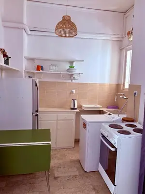 a kitchen with a white stove and a white refrigerator at Cósy apartment in Palaiá Fókaia