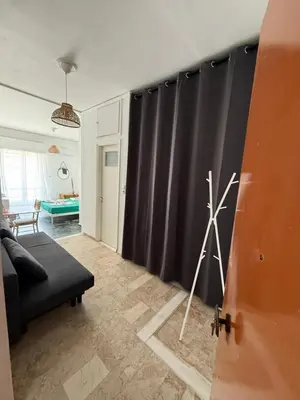 a living room with a black curtain and a tripod at Cósy apartment in Palaiá Fókaia