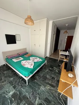a bedroom with a bed and a desk and a television at Cósy apartment in Palaiá Fókaia
