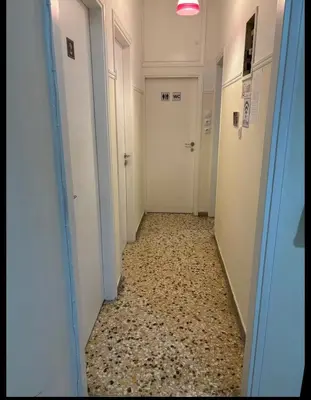 a hallway with two white doors and a tile floor at Dream room 3-4 in Athens
