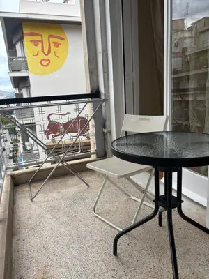 a table and a chair on a balcony at Dream room 3-4 in Athens