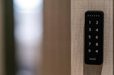 a black remote control sitting on the side of a curtain at Agora Views in Athens