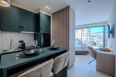 a kitchen with green cabinets and a sink with chairs at Agora Views in Athens