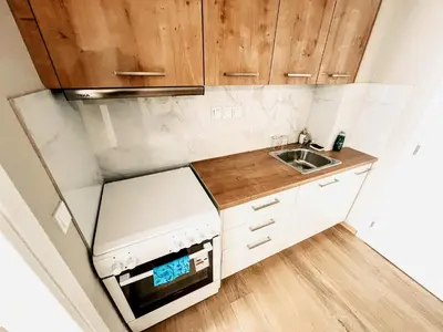 a small kitchen with wooden cabinets and a sink at Studios & Shared Roof to Acropolis in Athens