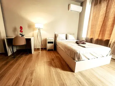 a bedroom with a bed and a desk and a lamp at Studios & Shared Roof to Acropolis in Athens