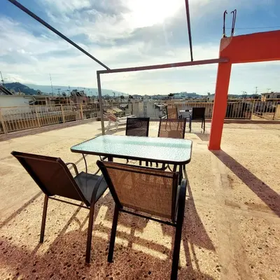a table and chairs on top of a roof at Studios & Shared Roof to Acropolis in Athens