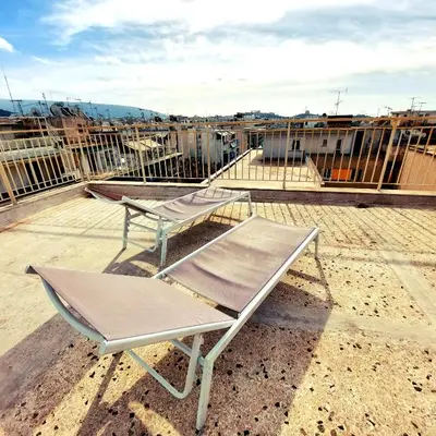 a chair and a table on top of a roof at Studios & Shared Roof to Acropolis in Athens