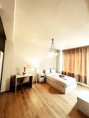 a bedroom with a bed and a table and a window at Studios & Shared Roof to Acropolis in Athens