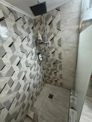 a bathroom with a shower with a tiled wall at Athens station 4 min walk , two bedroom apartment in Athens