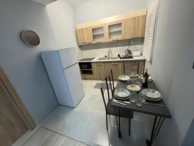 a small kitchen with a table and a refrigerator at Athens station 4 min walk , two bedroom apartment in Athens