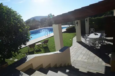 a patio with a table and chairs next to a pool at Villa Femy - 3 bedrooms, shared pool with 1 house in Anavissos