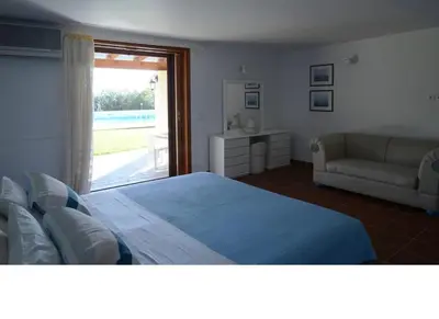 a bedroom with a bed and a couch and a window at Villa Femy - 3 bedrooms, shared pool with 1 house in Anavissos