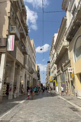 a group of people walking down a street with buildings at Zen Ermou City Center 2 in Athens