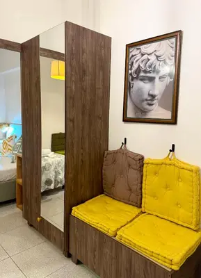 a yellow couch in a room with a mirror at Acropolis Gem in Central Athens in Athens