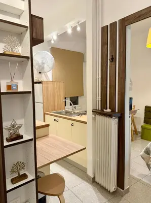 a kitchen with a table and a radiator in a room at Acropolis Gem in Central Athens in Athens