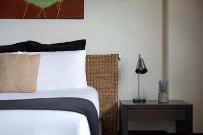 a bedroom with a bed and a table with a lamp at Calm Retreat Villa Lagonisi in Kalívia Thorikoú