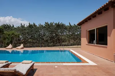 a swimming pool in front of a house at Calm Retreat Villa Lagonisi in Kalívia Thorikoú