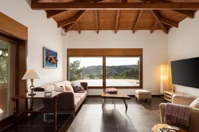 a living room with a couch and a large window at Calm Retreat Villa Lagonisi in Kalívia Thorikoú