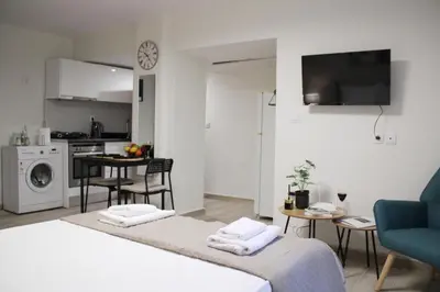 a living room with a bed and a kitchen at ARIS- King suite on the boulevard in Athens