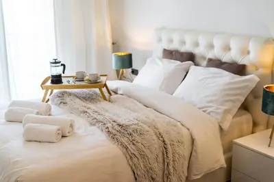 a bedroom with a large white bed with a side table at Luxury 3-bedroom Apartment Athens Nea Smirni in Athens