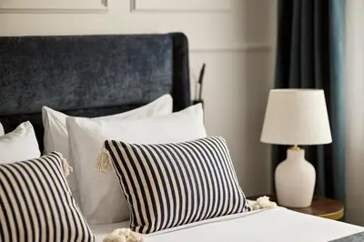 a bed with black and white pillows and a lamp at Acropolis Eclectic Residence in Athens