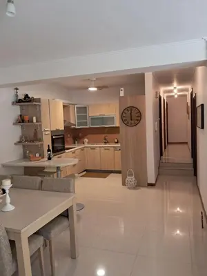a kitchen with a table and a clock on the wall at L D House Lagonisi in Lagonissi
