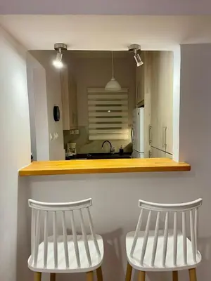 two white chairs sitting under a counter in a kitchen at Spacious 2-Bedroom Apartment - 10 minutes from Kallimarmaro in Athens