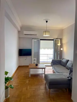 a living room with a couch and a table at Spacious 2-Bedroom Apartment - 10 minutes from Kallimarmaro in Athens