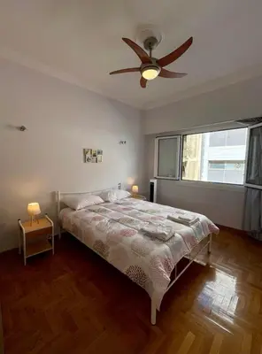 a bedroom with a bed and a ceiling fan at Spacious 2-Bedroom Apartment - 10 minutes from Kallimarmaro in Athens