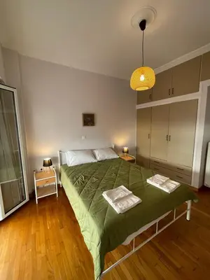 a bedroom with a bed with a green comforter at Spacious 2-Bedroom Apartment - 10 minutes from Kallimarmaro in Athens