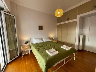 a bedroom with a green bed with two tables at Spacious 2-Bedroom Apartment - 10 minutes from Kallimarmaro in Athens