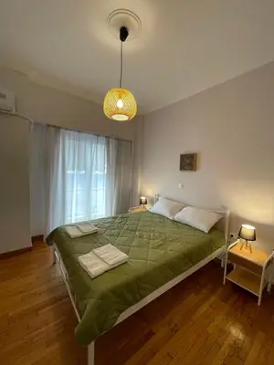 a bedroom with a large bed with a green blanket at Spacious 2-Bedroom Apartment - 10 minutes from Kallimarmaro in Athens