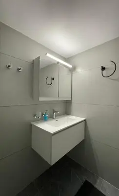 a white bathroom with a sink and a mirror at Spacious 2-Bedroom Apartment - 10 minutes from Kallimarmaro in Athens