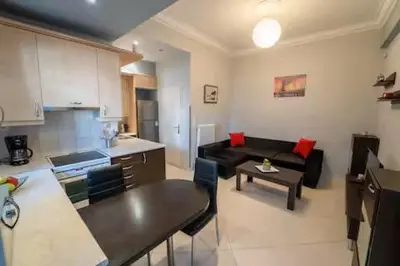 a kitchen and a living room with a couch and a table at Modern & Lovely Apartment Downtown Near Acropolis in Athens