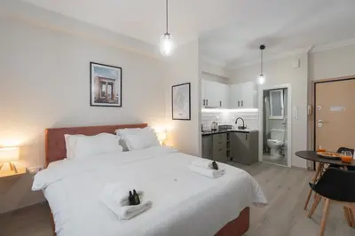 a bedroom with a large white bed and a bathroom at Cozy Studio in Plaka 10 Minutes From Acropolis in Athens