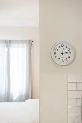 a clock hanging on a wall next to a bed at Cozy Studio in Plaka 10 Minutes From Acropolis in Athens