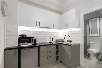 a white kitchen with a sink and a microwave at Cozy Studio in Plaka 10 Minutes From Acropolis in Athens